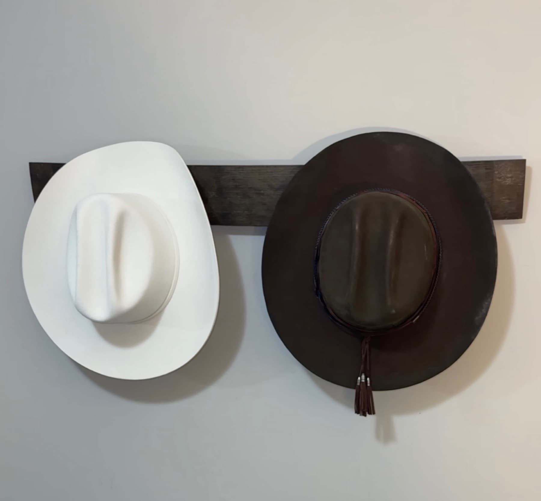 Handcrafted bourbon stave coat rack with two pegs on a wall
